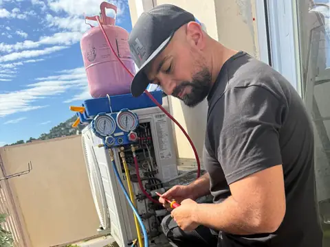 Technicien Vincent Services en intervention sur une unité extérieure de climatisation